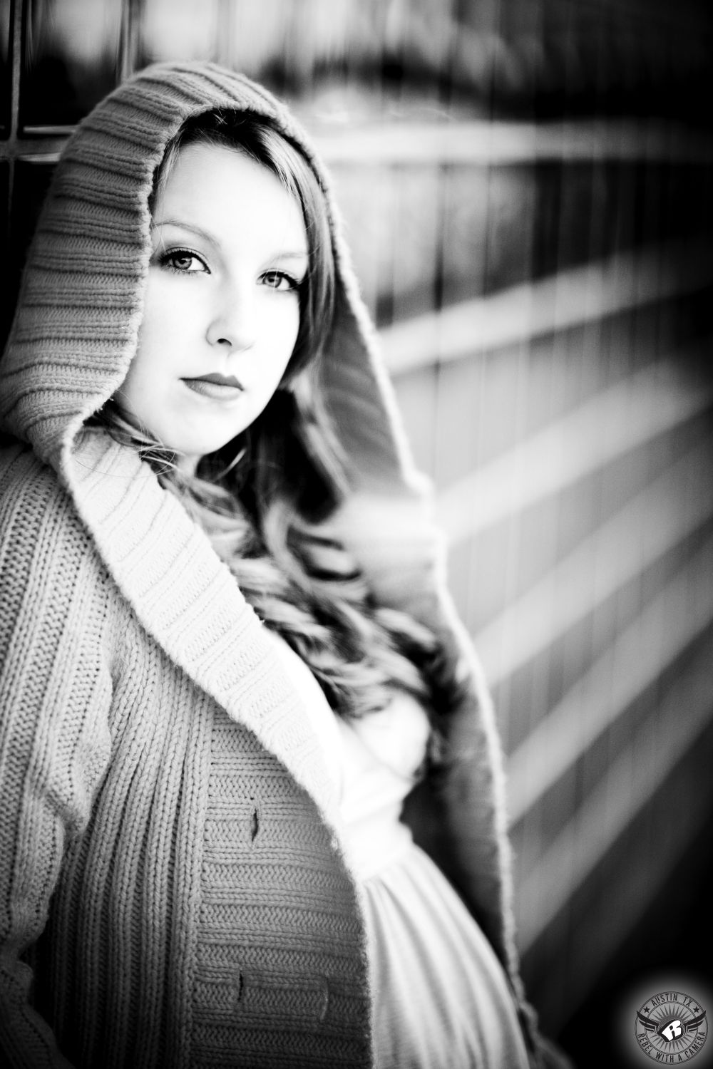 Black and white image of high school graduate in Austin, Texas, taken by Austin senior portrait photographer in the Warehouse District in front of glass block wall.